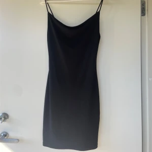 Svart axelbandslös klänning från Gina Tricot - Säljer en svart, enkel och stilren klänning från Gina Tricot i storlek XS. Klänningen har smala axelband och rak passform, perfekt för en trendig och minimalistisk look.
