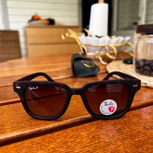 Ray-Ban solglasögon  - Snygga solglasögon från Ray-Ban med mörkbrunt sköldpaddsmönster och polariserade linser. Rektangulär form och klassisk design, perfekt för dig som vill ha en stilren accessoar.