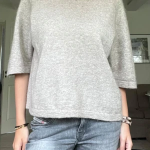 Trekvartsärmad tröja &OTHER STORIES - Mysig beige stickad tröja med trekvartsärm och avslappnad passform! Denna tröja är galet snygg att stylea tillsammans med en långkjol t.ex under sommaren, eller bara till ett par jeans annars!! Nypris var 790 kr, säljer för 400 kr😇