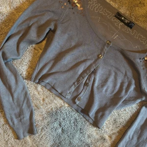 Croppad bolero med paljettdetaljer - fin cropped bolero/kofta. Inte använd mycket. Väldigt mjukt tyg. 