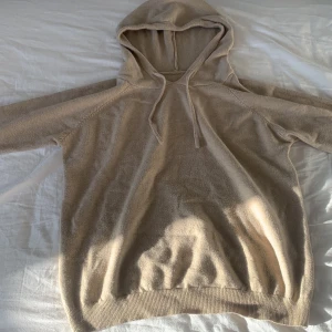 Beige stickad hoodie - Mysig beige stickad hoodie med huva.Perfekt för kyliga dagar och enkel att matcha med olika outfits. Tröjan har långa ärmar och ribbade muddar vid ärmslut och nederkant. Ettiktekn är borta så jag vet inte vad det är för märke men det är en merionull hoodie 100%. Likande hår för 999 typ mitt pris 449 pris går att diskutera. 