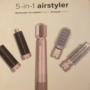 5-i-1 airstyler hårstyler - Multifunktionell airstyler i roséguld med fem utbytbara tillbehör för att skapa lockar, volym och släta frisyrer. Inkluderar två locktillbehör, två rundborstar och ett fönmunstycke. Perfekt för styling av olika hårtyper. 