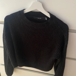 Svart stickad tröja från Vero Moda - Säljer en svart stickad tröja från Vero Moda. Tröjan har en klassisk rund halsringning och långa ärmar. Perfekt för kyligare dagar och enkel att matcha med olika outfits.