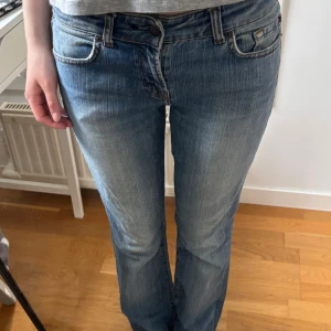 Blå bootcut jeans med broderade bakfickor - Blå bootcut jeans, storlek 38 men passar 34