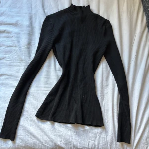 Svart ribbad polotröja - Säljer en svart ribbad polotröja med figurnära passform