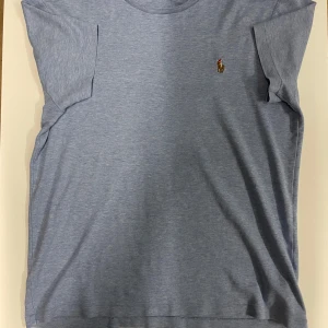 Blå t-shirt från Polo Ralph Lauren - Snygg ljusblå t-shirt från Polo Ralph Lauren som passar S och XS. Modellen är slim fit . Perfekt för en stilren och avslappnad look.