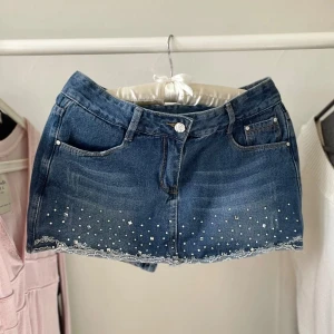 Jeanshorts med pärlor och spetsdetaljer - Vintage jeans shorts som ser ut som en kjol framtill 💕 midja: ca 38cm Brodyr och rhinestone detaljer !  Lappen är på japanska så antar att de är ett japanskt märke 🎀  