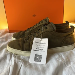 Louboutin sneakers  - Säljer ett par kakhi färgade sneakers från Christian Louboutin med klassisk röd sula. Skorna har snörningen boston two step och rund tå, samt en vit platt sula. Perfekta för dig som gillar stilrena och exklusiva sneakers. skicket får ni avgöra själva utifrån bilder och äkthets bevis kan tas fram vid intresse av köp. skorna i storlek 45 men kan nog passa 44 väldigt bra också. Endast skorna. Nypris på skorna ligger runt 8000. Jag tar gärna emot byten om du bor i Stocholm.