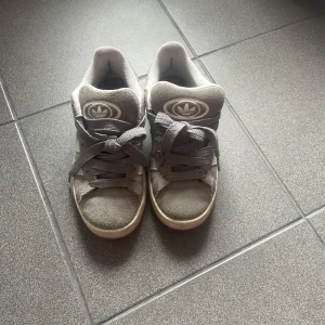 Grå Adidas sneakers med vita ränder - Säljer ett par grå Adidas Campus sneakers. 