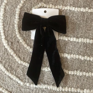 Svart rosett från H&M - Stilrent svart diadem från H&M med stor rosett i mjuk sammet. As snygg för att pimpa upp olika frisyrer. 