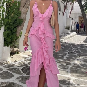 Rosa volangklänning från PrettyLittleThing - Säljer en lång rosa klänning från PrettyLittleThing med volangdetaljer. Klänningen har smala axelband och är tillverkad i ett lätt, skrynkligt material. Kom sent till min semester så aldrig använt den. Dock saknar prislapp då jag provat den hemma och inte haft tillfälle att använda den ännu. 