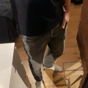 Jack & Jones jeans - Säljer ett par grå slim fit jeans från Jack & Jones, modell Glenn och i storleken 32/30. Klassisk femficksdesign med knappgylf och diskreta sömmar. Perfekta för dig som gillar en smalare passform och stilren look.