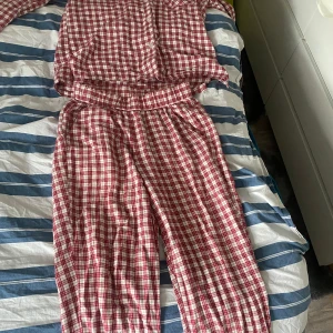 Rödvitrutiga pyjamasbyxor från Kappahl - Mysiga pyjamasbyxor från Kappahl i rödvitt rutigt mönster. Byxorna har en avslappnad passform och är tillverkade i mjuk bomull, perfekta för hemmakvällar. Matchande skjorta finns också. Aldrig använda då de inte passar mej