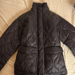Svart quiltad pufferjacka från Esmara - Säljer en svart quiltad pufferjacka från Esmara i storlek XS. Jackan har en hög krage och långa ärmar, aldrig använd då jag glömt bort att de. Ursprungspris 400kr