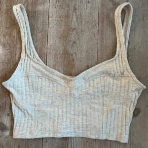 Beige ribbad topp - Säljer en snygg beige ribbad ”korsettopp”/linne med smala axelband. Toppen är aldrig använd! Från H&M i storlek S🤍