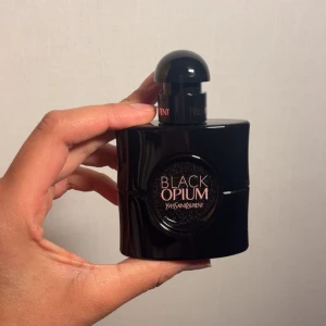 Black Opium Le Parfum från Yves Saint Laurent - Säljer en flaska Black Opium Le Parfum från Yves Saint Laurent. Flaskan är elegant och svart med en glittrande yta och rundad form. Parfymen kommer i en 30 ml flaska och är känd för sin djärva och sensuella doft, använd endast en gång