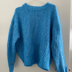 Blå stickad tröja från 157 - Säljer en härlig blå stickad tröja från 157. Tröjan har en avslappnad passform med långa ärmar. Liten i storleken, därav Large