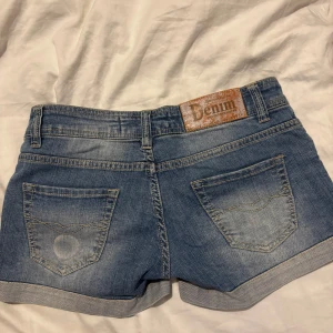 Lågmidjade jeansshorts från Bershka - Snygga blå jeansshorts från Bershka med låg midja. De har en knapp och dragkedja framtill.
