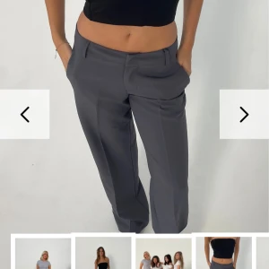 Grå kostymbyxor - BRITNEY LOW WAISTED SUIT PANTS  - Snygga grå kostymbyxor med en klassisk design. Byxorna har en lågmidjad passform och raka ben. Perfekta till allt! Storlek S och längd reguler. Hör av vid frågor! Egna bilder kan skickas privat. Köptes för 605 säljs för 460kr