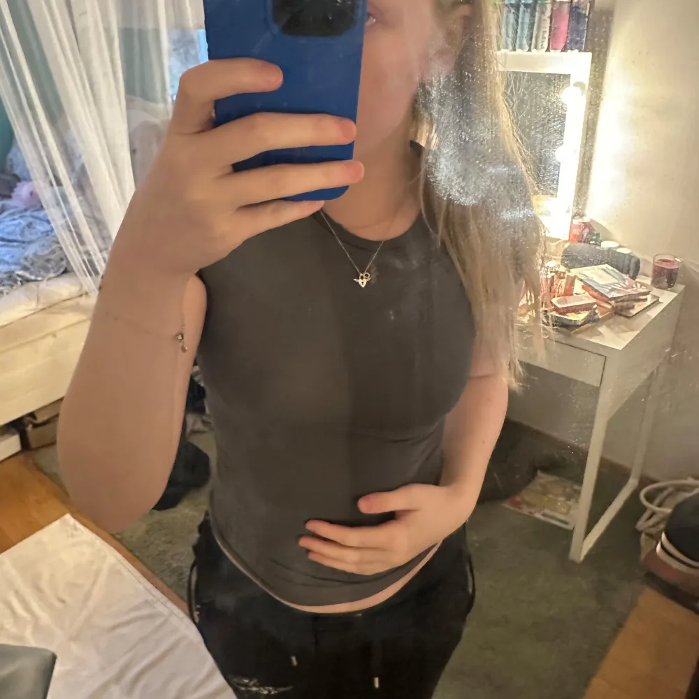 Säljer en stilren grå t-shirt från H&M. Den är kortärmad och har en normal passform, perfekt för en avslappnad look. Materialet känns mjukt och bekvämt mot huden, material som är lite sportigt och likt skims material. T-paidat.