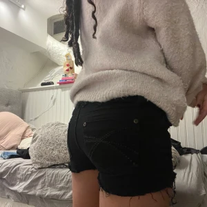 Svarta lågmidjade jeansshorts  - Snygga svarta lågmidjade jeansshorts med fransiga kanter och dekorativa sömmar på bakfickorna. Så söta till sommaren, säljer då jag tycker dom är lite korta på mig. Kan tänka mig att sänka priset💓