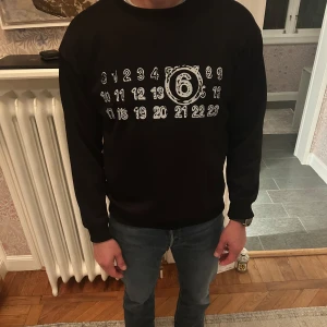 Maison margiela tröja - Säljer en svart vit maison margiela tröja åt min kompis i storlek M. Finns inga fel eller skador på sig. Säljer den åt min kompis då han bad mig göra det för jag sålde en likadan i vit. Modellen är 180cm och 75 kg. Men skriv gärna era mått så kan jag säga hur jag tror den sitter