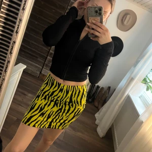 Mönstrad kjol - Trendig kortkjol med zebramönster i gult och svart. Perfekt för att sticka ut med en djärv look. Kjolen har en tight passform som framhäver figuren.