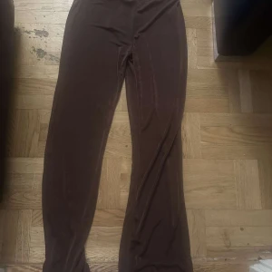 Bruna vida byxor i sammet - Mysiga bruna byxor i mjuk sammet med vida ben. Perfekta för dig som gillar en avslappnad och trendig stil. Byxorna har hög midja och är riktigt sköna att bära.