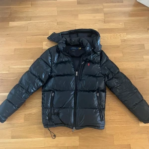 Polo Ralph Lauren svart gloss jacka - Hej! Säljer nu min Ralph Lauren jacka efter en vinters användning. Den är i bra skick utan några defekter. Den är i storlek S men passar mig som är vanligtvis storlek M. 