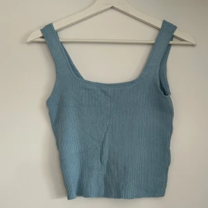 Ljusblå ribbad linnetopp från H&M Divided - Säljer en ljusblå ribbad linnetopp från H&M Divided. Toppen har breda axelband och en rundad halsringning. Perfekt för varma dagar och enkel att matcha med olika outfits. Använd fåtal gånger.