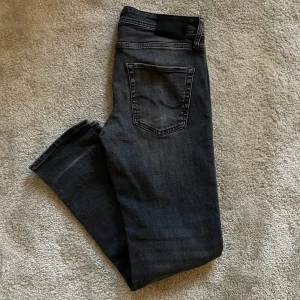 Svarta/Gråa jeans från Jack and Jones - Snygga svarta/Gråa jeans med en snygg wash från Jack and Jones. Jeansen har en Slimfit/straightleg passform. Hör av dig ifall du undr att något mer😁