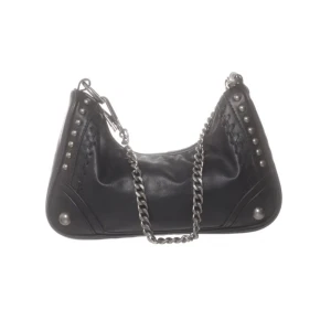 Svart axelväska med kedja från Zara - Säljer en svart axelväska från Zara i skinnimitation med silverfärgad kedja som axelrem. Väskan har nitar och dekorativa sömmar på sidorna för en edgy look. Perfekt storlek för det viktigaste och lätt att matcha till olika outfits.
