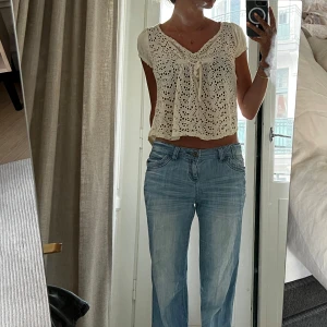 Beige spetsblus med rosett från Odd Molly - Supersöt beige/gul blus från Odd Molly i spets med v-ringning och liten rosett framtill. Blusen är croppad och har korta ärmar. Storlek s.