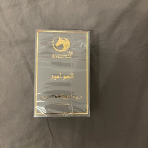 Al Hawamir Eau de Parfum - Exklusiv parfym från Lattafa med lyxig svart och guldig förpackning. Flaskan rymmer 50 ml och är en Eau de Parfum. Designen har eleganta gulddetaljer och arabiska inskriptioner, vilket ger en känsla av lyx och mystik. Parfymen är därmed från Dubai i så det är riktigt fin doft. 