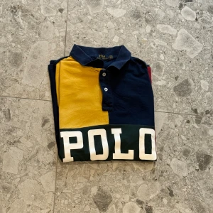 Flerfärgad pikétröja från Polo Ralph Lauren - Säljer en pikétröja från Polo Ralph Lauren i färgblock med marinblått, gult, grönt och rött. Nypris ligger på cirka 1500kr