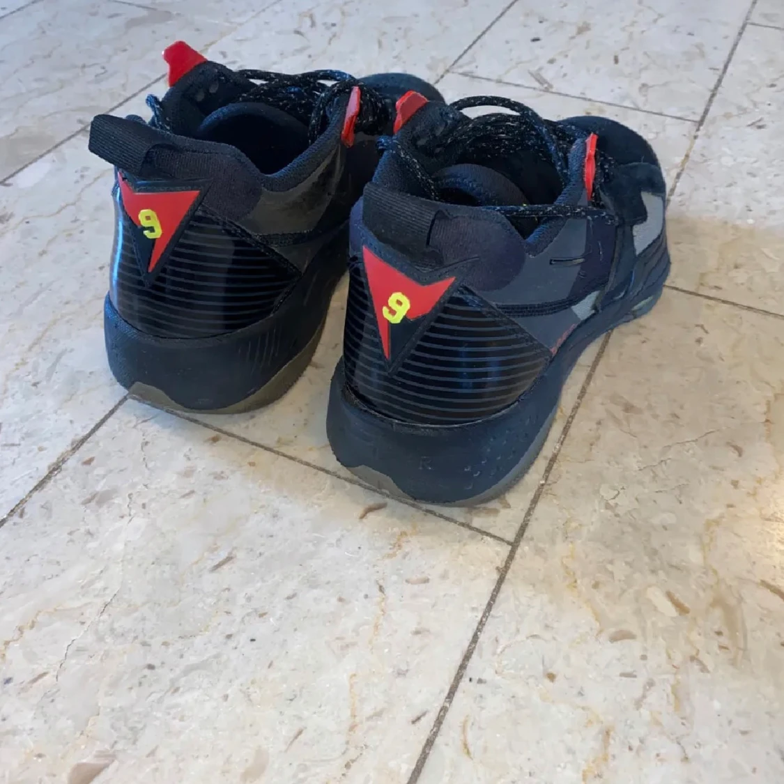 Svarta Nike Air Jordans med röda och gula detaljer - 1