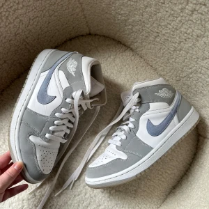 Air Jordan 1 Mid Wolf Grey Aluminium  - Säljer ett par Jordans i en populär modell ”Air Jordan är mid Wolf Grey Aluminum” köpta på Jdsports. Sparsamt använda och i fint skick, rengjorde inför försäljning med Nike’s tvättguide.  Säljes runt 3000:- som nypris.  Kom med prisförslag!  Storlek:39