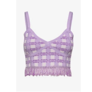 Lila croppad linnetopp med fransar från Baum und Pferdgarten - Trendig lila linnetopp med rutigt mönster och fransar längst ner. Toppen har smala axelband och är croppad, perfekt för en somrig look. Snygg detalj med genomskinliga partier och struktur i materialet. Nypris 1299:- använt 1 gång 