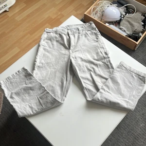 Ljusgrå cargopants från Yoke - Säljer ett par ljusgrå cargopants från Yoke med flera praktiska fickor på sidorna och bak. Byxorna har normal passform och är tillverkade i ett slitstarkt bomullsmaterial. Perfekta för dig som gillar en avslappnad och funktionell stil.