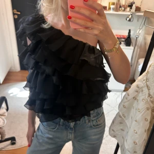Söt topp - Snygg svart topp med volanger och oneshoulder. Endast använd en gång🥰