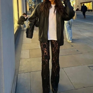 Svarta spetsbyxor med utsvängda ben - Säljer ett par svarta byxor i spets med blommigt mönster och utsvängda ben. I perfekt skick. Första och sista bilden är lånade. 