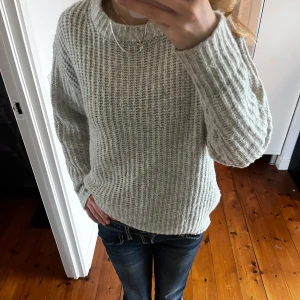 Ljusgrå stickad tröja  - Mysig ljusgrå stickad tröja från 157 med grovstickat mönster och rund halsringning. 