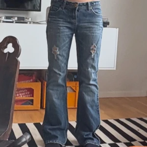 Blå bootcut jeans med slitningar - Snygga blå bootcut jeans med slitningar på båda knäna 
