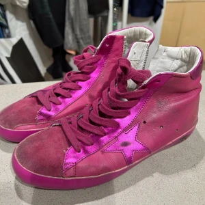 Golden goose rosa sneakers  - high top sneakers från golden goose i olika nyanser av rosa med metallic-detaljer och en stjärna på sidan. Skorna har en liten klack och är tillverkade i skinn.