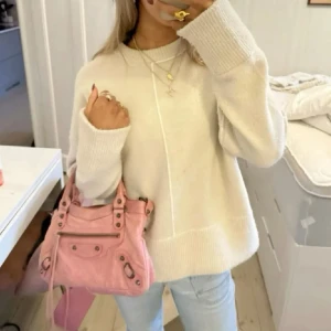 Stickad tröja - Säljer en stickad tröja  med vita kontrastsömmar. Tröjan har lång ärm, hög hals och är tillverkad i mjuk ullmix. Perfekt för dig som gillar en chill och trendig look.