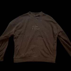 Svart fleece-tröja från Balenci - Svart fleece-tröja från Balenci med broderad logga på bröstet. Tröjan har rund halsringning och långa ärmar, perfekt för dig som gillar en clean och stilren look. Mjuk och skön fleece som håller dig varm under kyliga dagar.