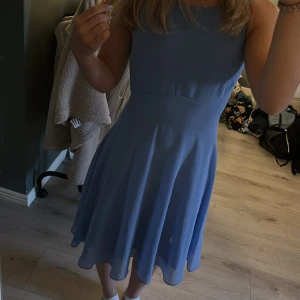 Blå kortklänning från Esprit - Supersöt blå klänning från Esprit med knytband i midjan baktill och ärmlös design. Klänningen har en lätt utsvängd kjol. Oanvänd då ja hittade en annan klänning. Pris går att diskutera💕