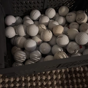 Golfbollar 83 stycken  - Bilden visar en låda fylld med golfbollar. 