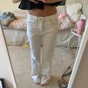 Vita raka jeans - Säljer ett par vita jeans med rak passform och klassisk femficksdesign. Byxorna har normal midja och är tillverkade i ett stadigt bomullstyg. Perfekta för dig som vill ha en clean och fräsch look.