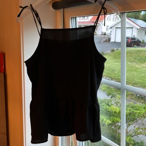 svart topp med rosett - jätte söt svart topp med två rosetter vid banden, använd få gånger och i skick som ny! passar mig ganska bra som är 164